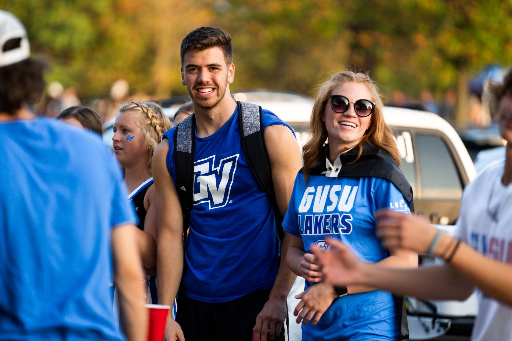 Students smile wearing GVSU gear before a football game